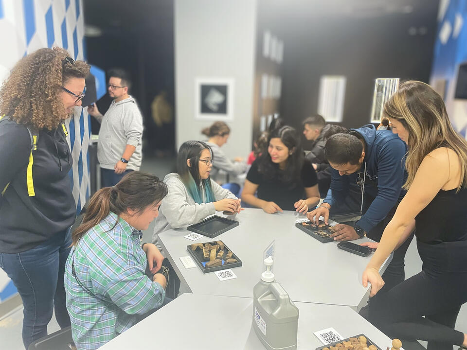 Untitled Rendezvoux members collaborating around a workshop table.